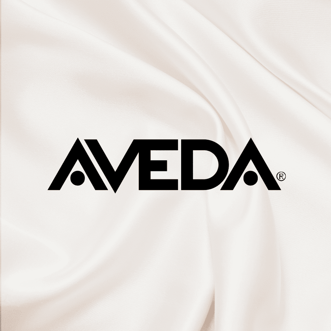 Aveda logo on a white satin fabric background.